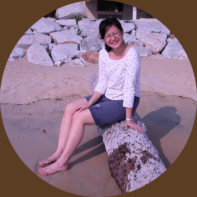 Juliane sitting on a log on a beach in Pangkor Island